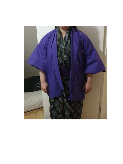 Kimono mit der Jacke (Haori) in Violett und einer Perlenkette in den Farben schwarz und violett.