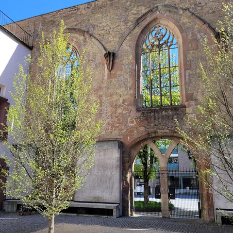 Hof der Kirche mit Fenstern ohne Glas und links einer kleinen Birke