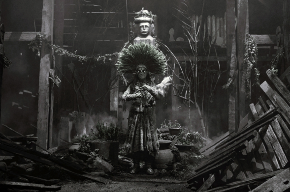 »The Northman«-Standbild: Björk als schicksalsstrippenziehende Priesterinn im Lande der Rus in niedergebranntem Heiligtum.