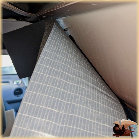 Das Armaflex ist an die Wand eines Autos geschraubt. Noch biegt es sich von der Wand weg, die Schutzfolie ist noch auf der Klebefläche. 