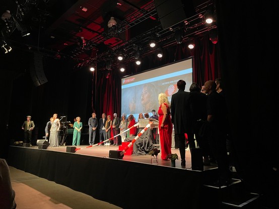 Foto einer vollen Bühne, auf der alle Preisträger:innen, Jurys und alle Beteiligten des Abends stehen