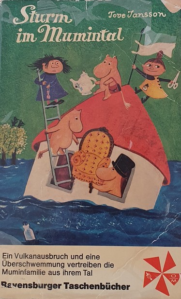 Cover von: Sturm im Mumintal, Autorin: Tove Jansson 
Das Haus der Mumins schwimmt auf einem Fluss, Muminpapa reicht einen Sessel durchs Fenster hinaus an Muminmamma. Die steht auf einer Leiter, die aus dem Fenster daneben ragt. Weitere Familienmitglieder sind weiter oben auf der Leiter und auf dem Dach.